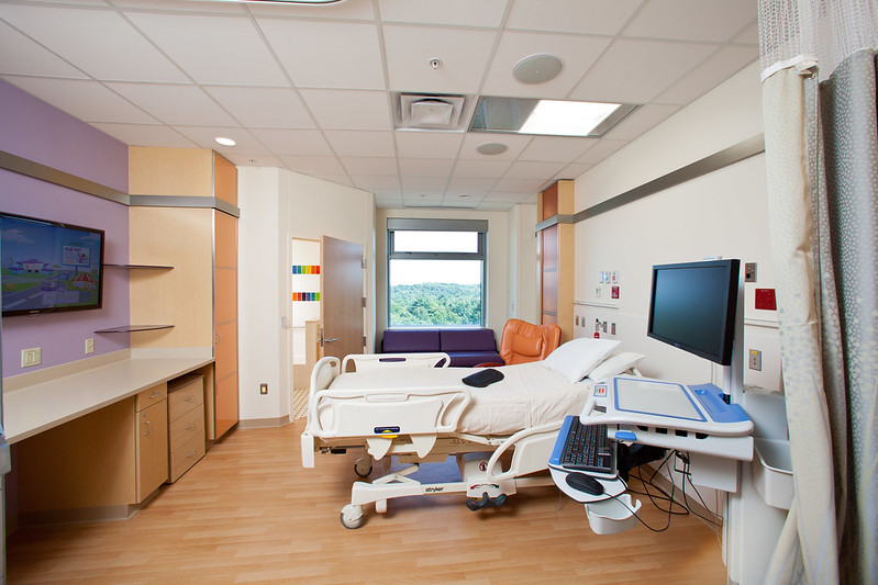 Empty patient room with TV and scenic view through window
